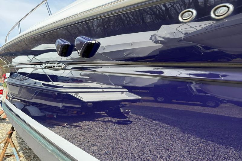 Glossy navy blue boat hull reflecting its surroundings after detailing