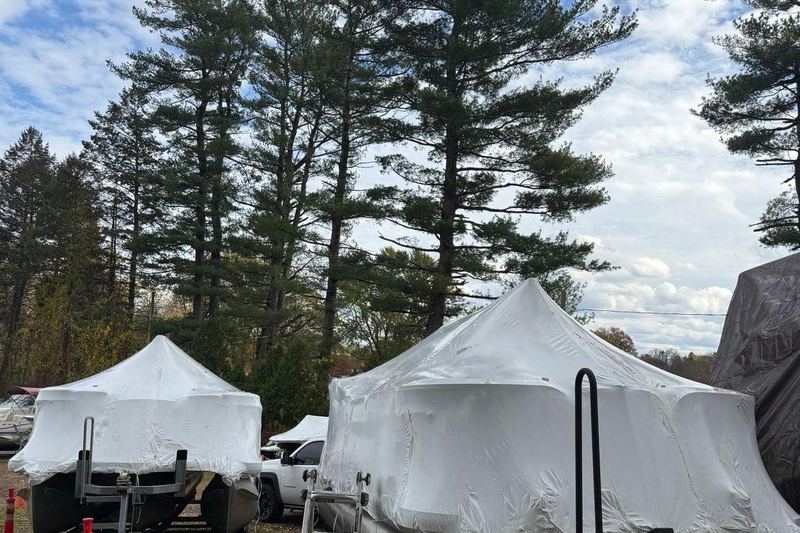 Two boats wrapped and stored on their trailers.